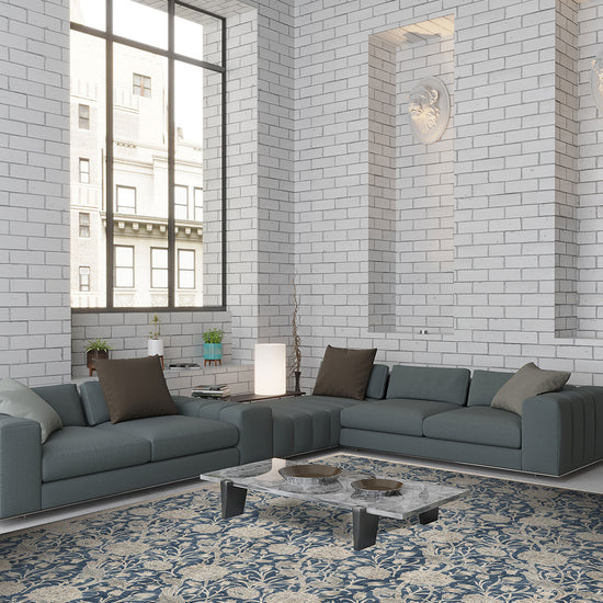 Modern living room with gray sectional sofa, coffee table, and decorative rug on white brick walls.