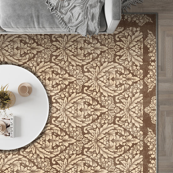 Patterned beige and brown rug in a room with a sofa and small table.