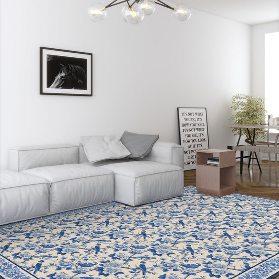 Living room with a blue and white patterned rug, gray sofa, and modern chandelier.