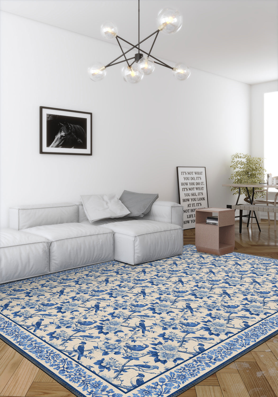 Living room with a blue and white patterned rug, gray sofa, and modern chandelier.